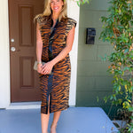 Woman in a tiger print dress standing on a porch