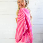Woman wearing a pink and white striped outfit against a white wooden panel background