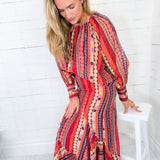 Woman wearing a colorful patterned dress against a white background