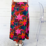 Person wearing a colorful star-patterned skirt against a white background