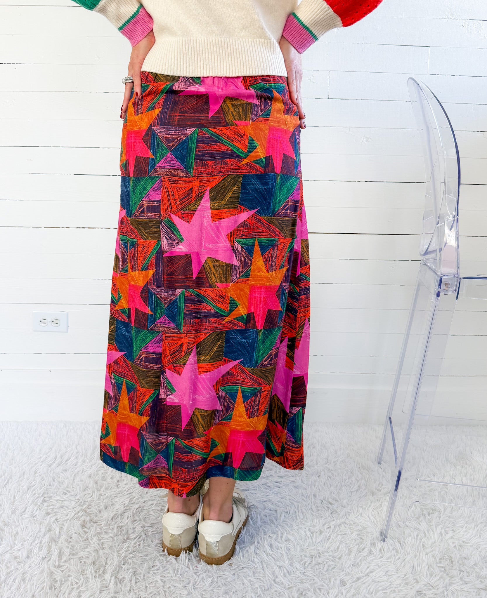Person wearing a colorful star-patterned skirt against a white background