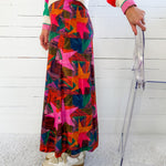 Person wearing a colorful patterned skirt with a white background