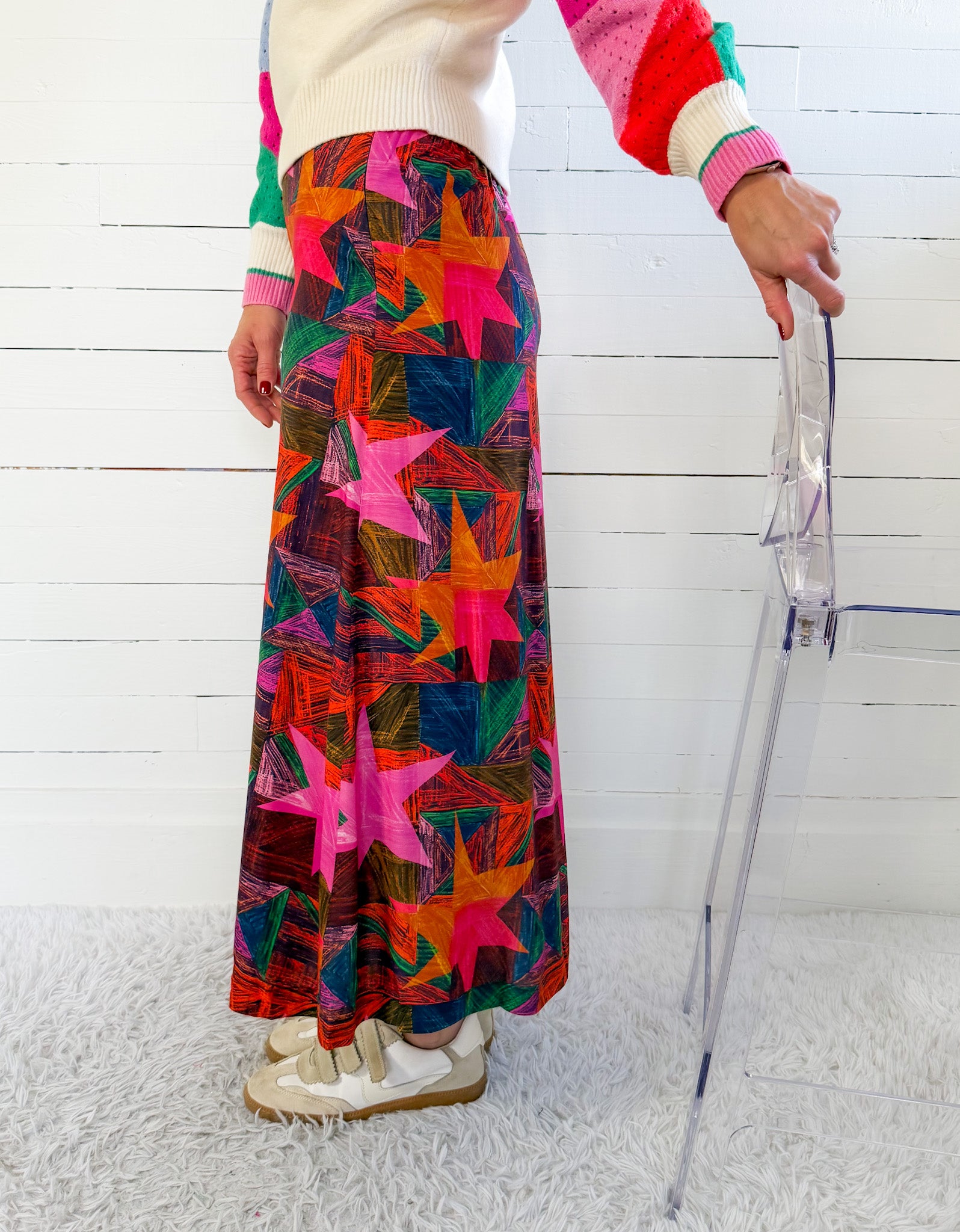 Person wearing a colorful patterned skirt with a white background