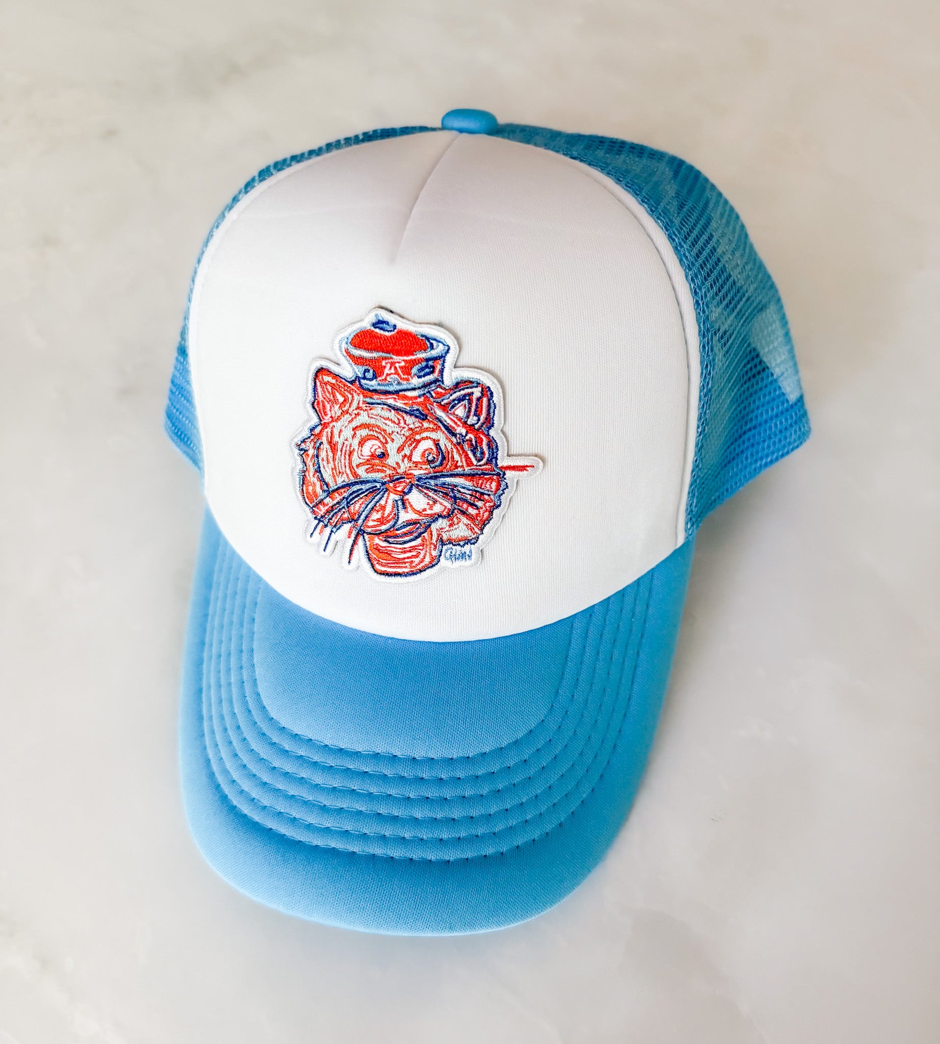 Blue and white cap with a tiger logo on a light gray background