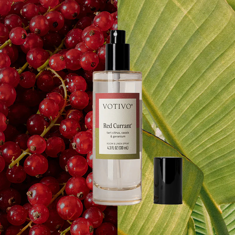 Votivo Red Currant perfume bottle with red currants and a green leaf in the background