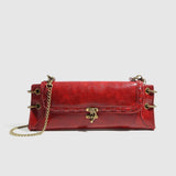 Red handbag with gold chain and clasp on a light gray background