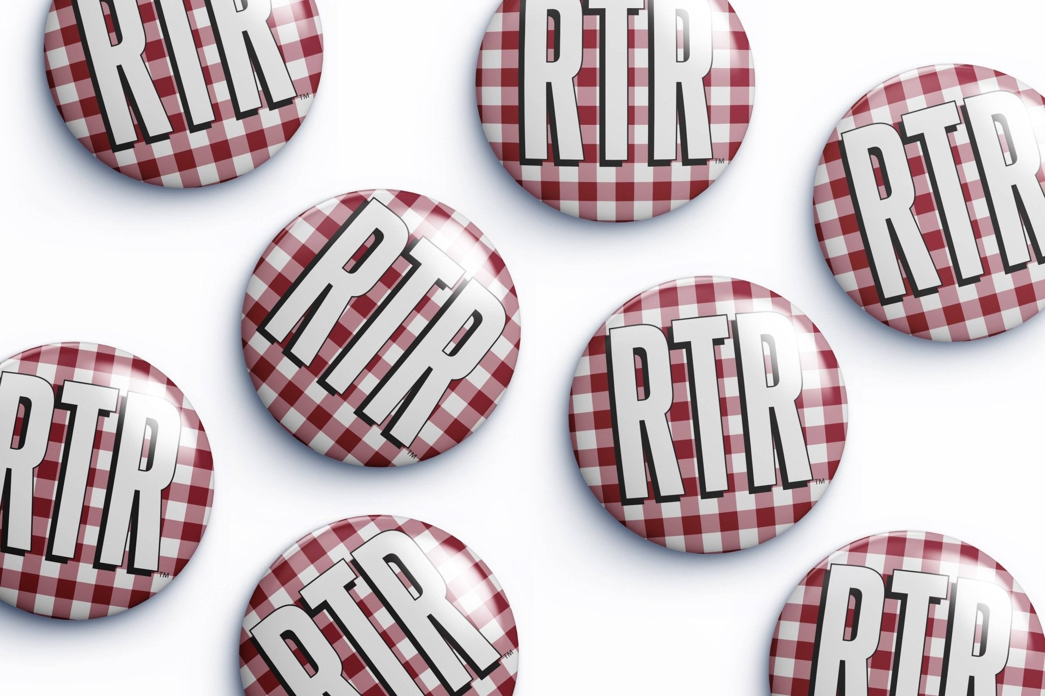 Several round pin-back buttons with a red and white gingham pattern and the letters 'RTR' in bold white with black outlines, arranged on a white background.
