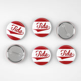 Six round pin-back buttons with a red and white striped design and the word 'Tide' in red script, shown on a light gray background with two front views and two back views.