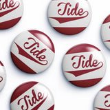 Several round button badges with the word Tide in red script over a white and dark red striped design, arranged on a light gray background.