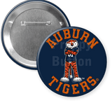 Two circular Auburn Tigers pinback buttons shown on a white background, with one button displaying the front design featuring the tiger mascot and orange text, and the other showing the metallic silver pin-back back.