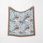 Fabric with vintage-style illustrations and text hanging on a white background
