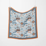 Fabric with vintage-style illustrations and text hanging on a white background