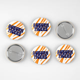 Six round pin-back buttons with Auburn Tigers branding, showing both front and back views on a light gray background.