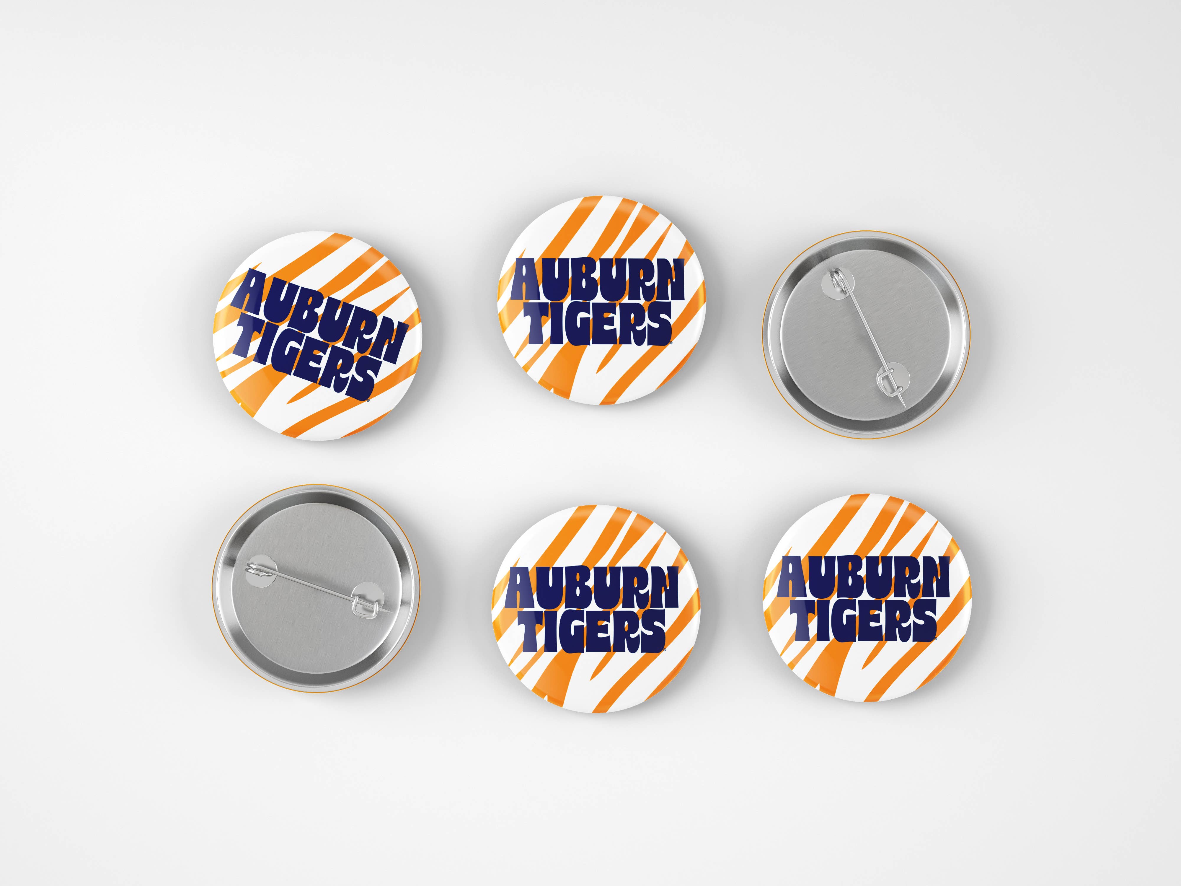 Six round pin-back buttons with Auburn Tigers branding, showing both front and back views on a light gray background.