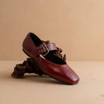 Brown leather shoe with buckle on a beige background