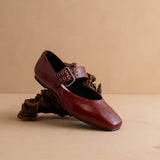 Brown leather shoe with buckle on a beige background
