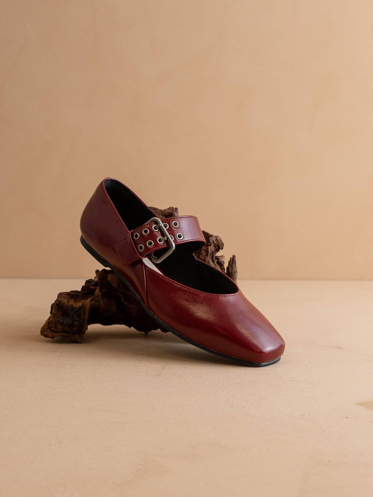 Brown leather shoe with buckle on a beige background