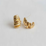 Gold hoop earrings on a light gray background