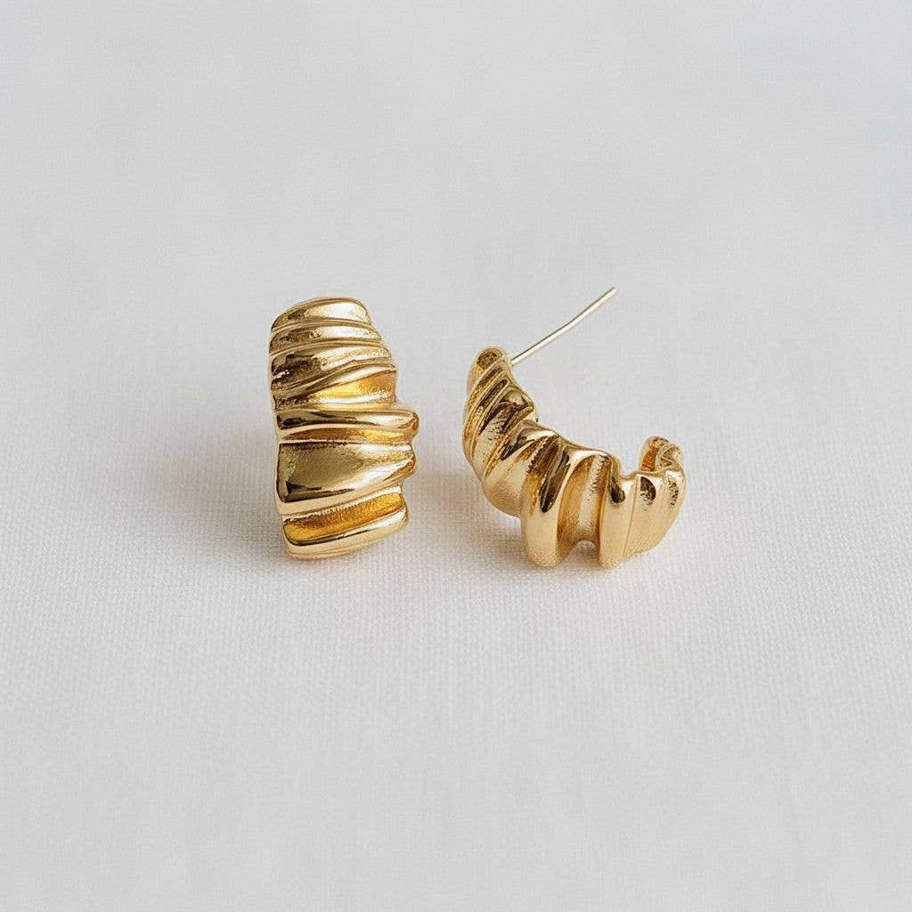 Gold hoop earrings on a light gray background