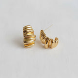 Gold hoop earrings on a light gray background