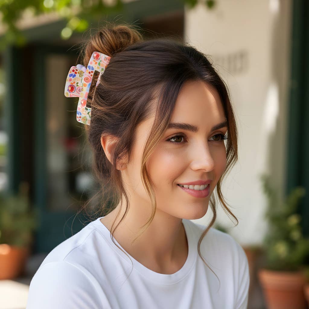 Woman with colorful hair clips in her hair, smiling outdoors.