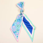 Colorful floral patterned hair tie on a beige background