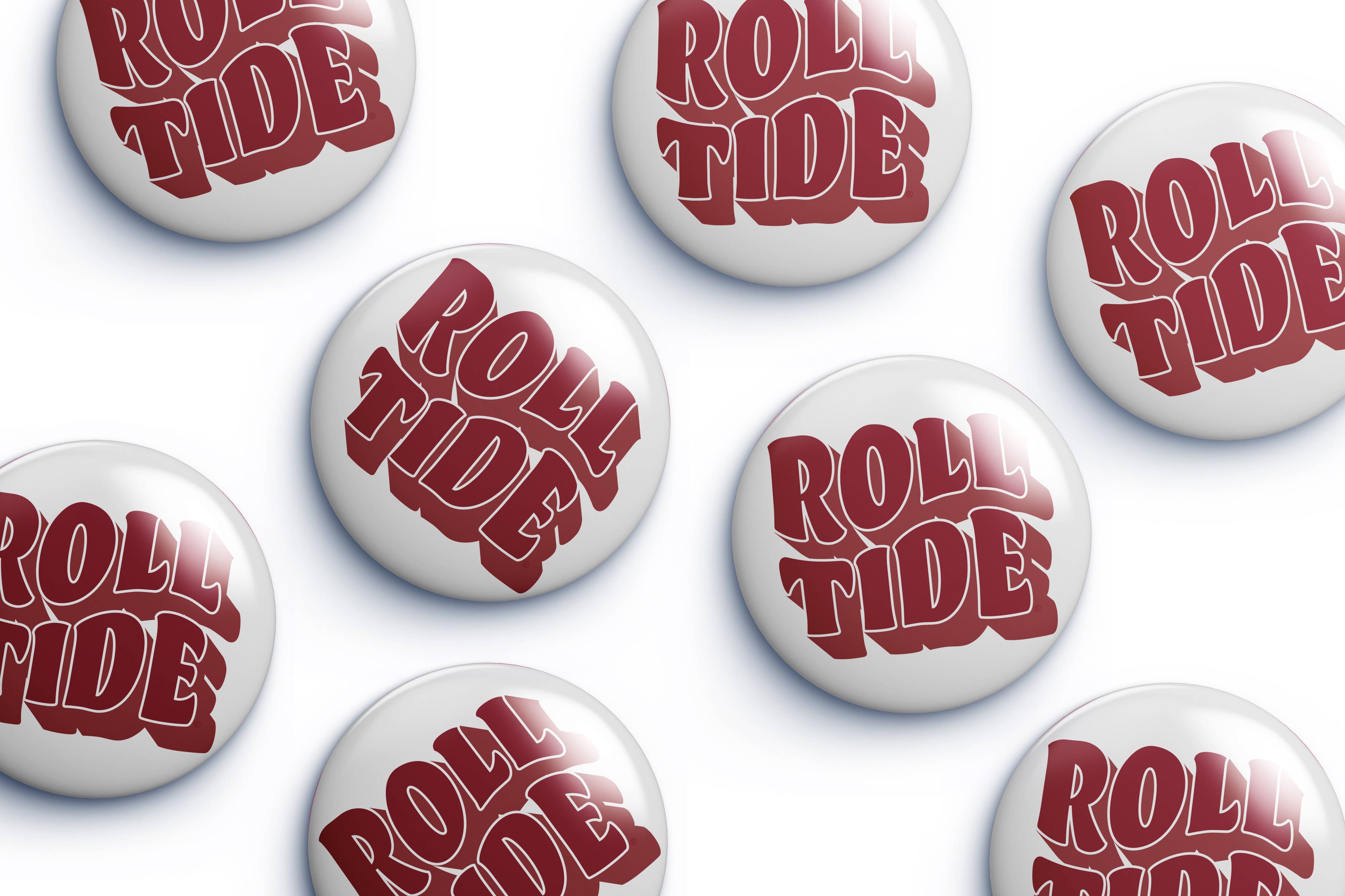 Several round white button badges with the words "ROLL TIDE" in large red stylized lettering, arranged on a light gray background.