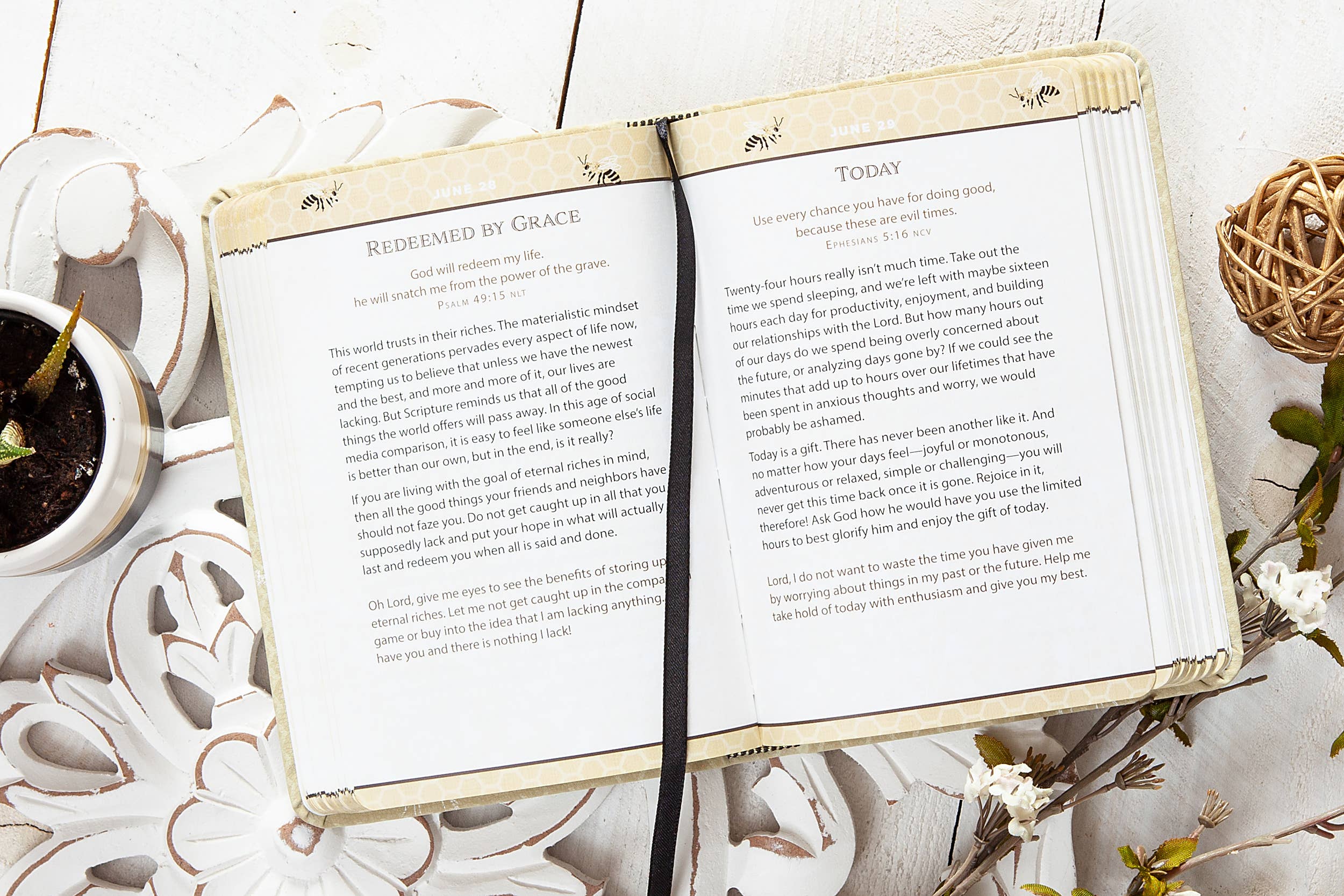Open book with text on a decorative surface with plants and flowers