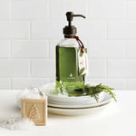 Green bottle with pump dispenser on a white surface with decorative elements