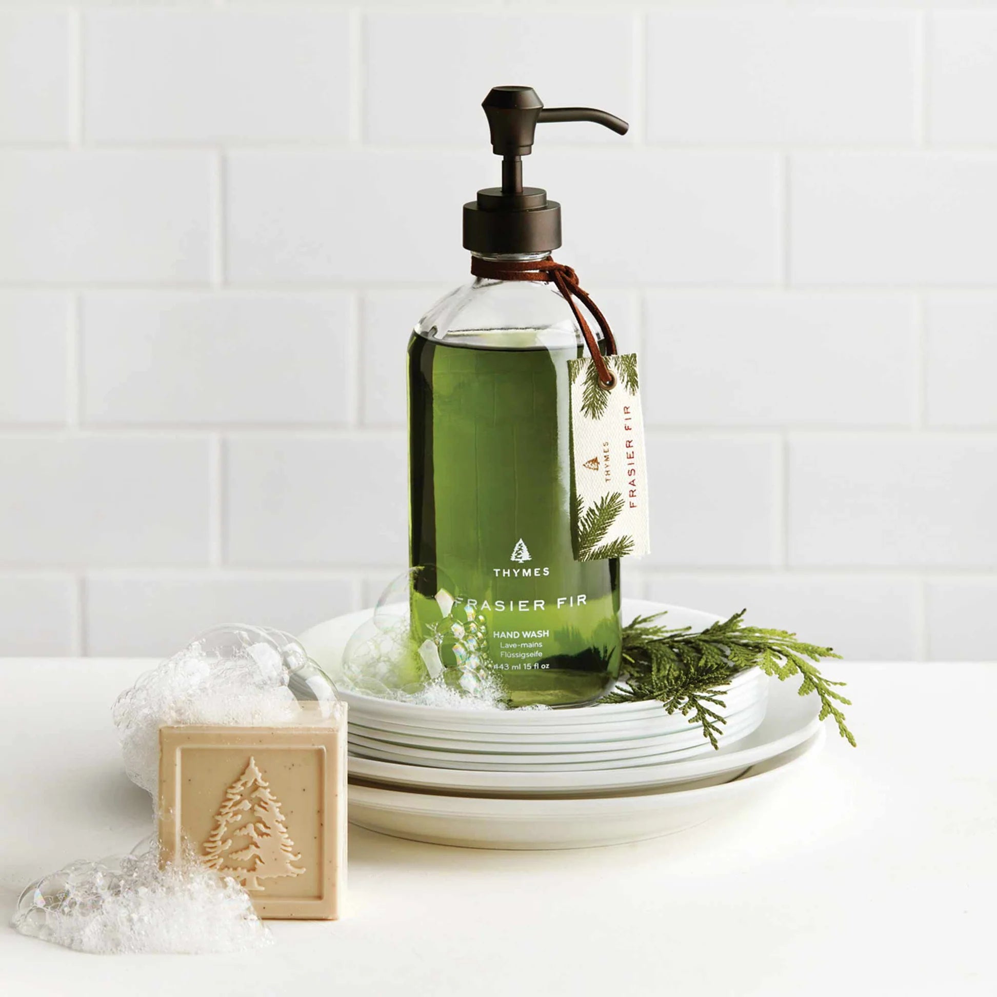 Green bottle with pump dispenser on a white surface with decorative elements