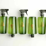 Five green spray bottles with black nozzles on a white background