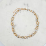 Gold and silver chain necklace on a marble surface