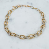 Gold and silver chain bracelet on a marble surface
