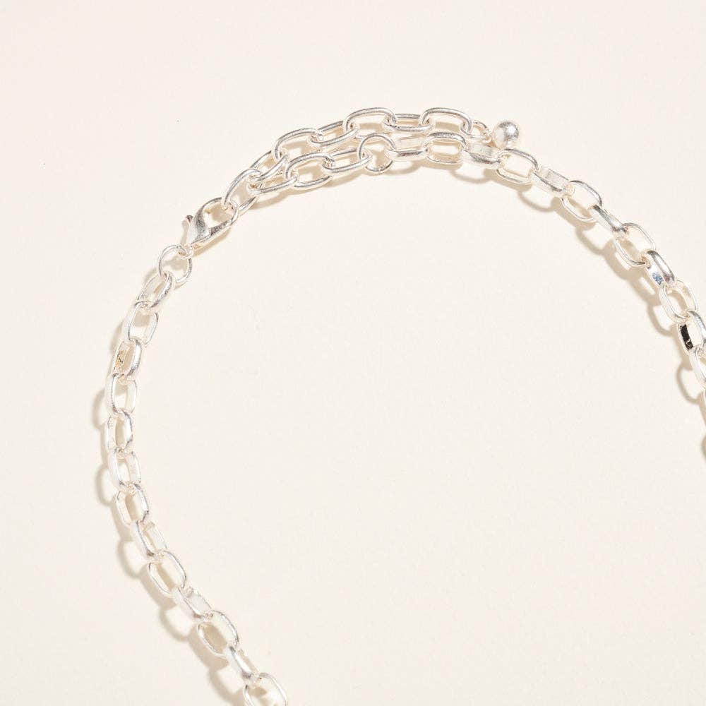 Silver chain bracelet on a light beige background