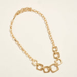 Gold chain necklace on a beige background