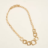 Gold chain necklace on a beige background