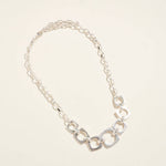 Silver chain necklace on a light beige background