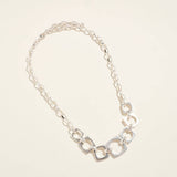 Silver chain necklace on a light beige background