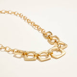 Gold chain bracelet on a light beige background