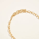 Gold chain bracelet on a light beige background