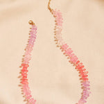 Necklace with pink and red beads on a beige background