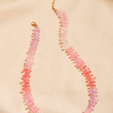 Necklace with pink and red beads on a beige background