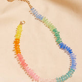Necklace with multicolored beads on a beige fabric background