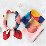Colorful patterned scarves on a white surface