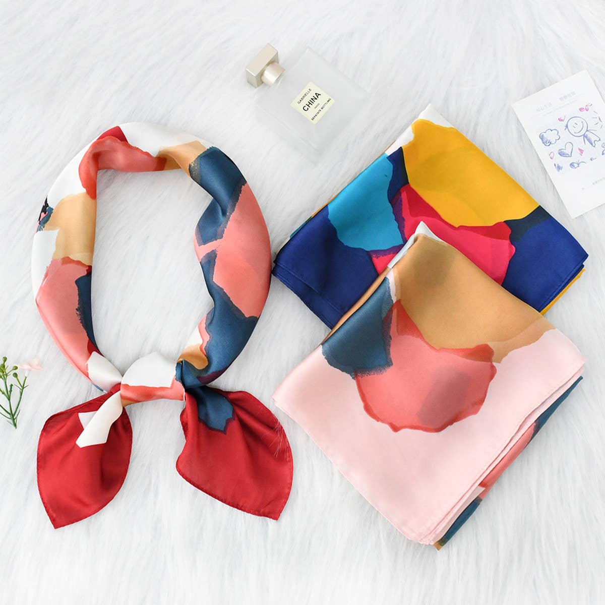 Colorful patterned scarves on a white surface