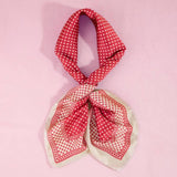 Red polka dot scarf on a pink background