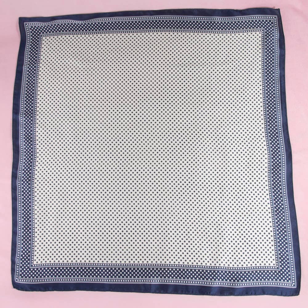 Navy blue and white patterned square scarf on a pink background