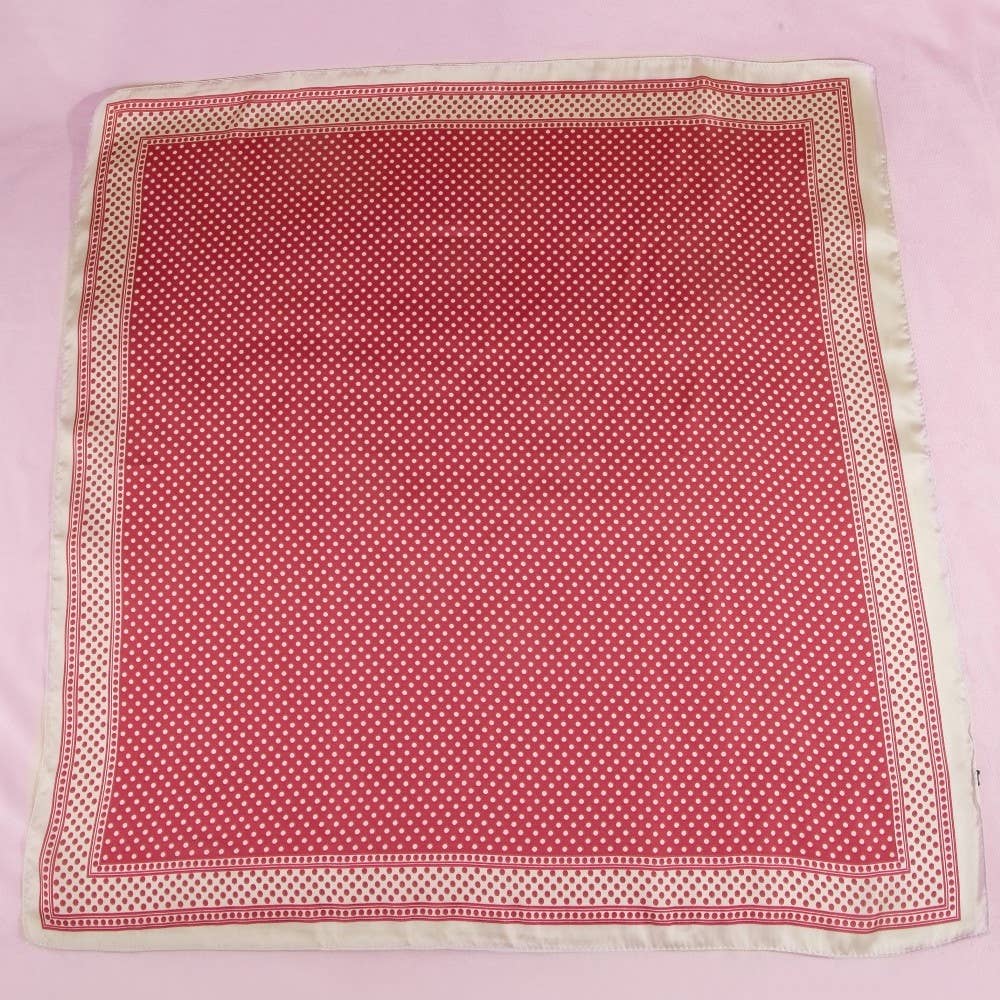 Red fabric with white polka dots on a pink background