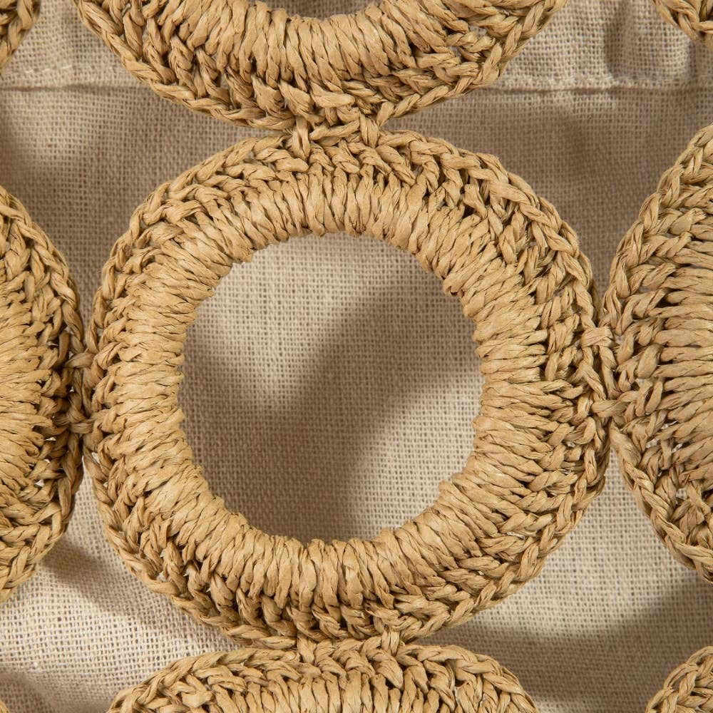 Close-up of woven circular coasters on a textured beige background