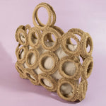 Woven basket with circular patterns on a pink background
